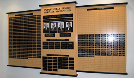 Three-panel bamboo laminated donor wall, with black metal dimensional lettering, metal printed photos and black aluminum plates to recognize donors and sponsors.