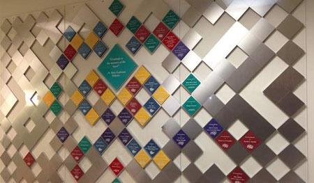 Assembled on large acrylic panels for easy hanging and removal, this wall incorporates satin aluminum blocks and colorful acrylic to form a quilt pattern with each color representing a level of giving.