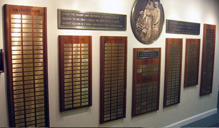 Walnut plaques with fluted columns, brass plates and header copy engraved into wood. Top headers and large, round center plaque are cast bronze. Center bas-relief created from artwork drawn by a friend of the Sisters'.