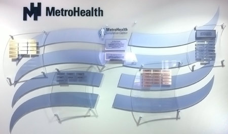 A contemporary, fluent pattern of laser-cut silver finished panels, combined with silver-standoff mounted plaques, crafted for adding engraved nameplates of perpetual donors.