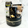 Vegan gift basket featuring biscotti, pistachios, gourmet crisps, olives, and fairtrade dark chocolate