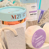 Close-up of lavender themed spa basket with self-care products, tea, eye mask, and bath accessories
