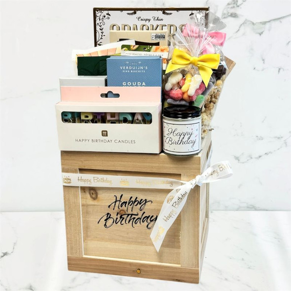 birthday crate with assorted snacks, chocolate, gummies, crackers, and festive birthday items