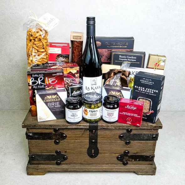 The Connoisseur Collection luxury non-alcohol gourmet food basket with cheeses, chocolates, La Kaya beverages and vintage wooden trunk.