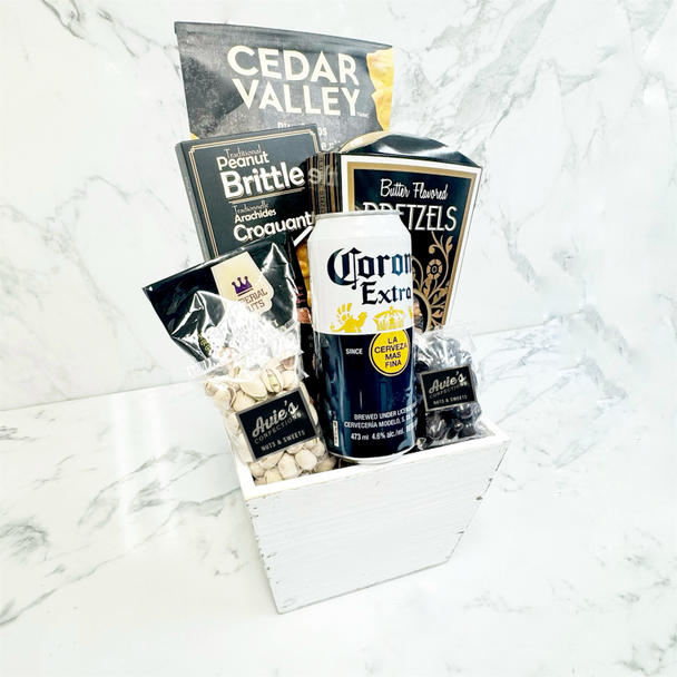 Game night gift basket featuring savoury snacks, chocolate-covered almonds, peanut brittle, and beer