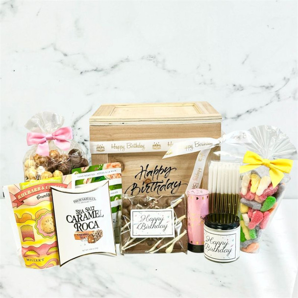Birthday gift crate featuring caramel corn, roca, biscuits, candle, confetti popper, and sweet treats