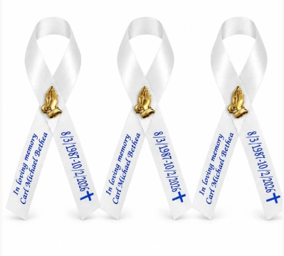 white ribbon with blue lettering and gold praying hands embellishment