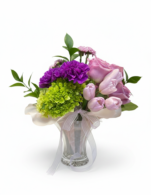 Send Mom a one of a kind vintage, hand-crafted keepsake from Duncan & Miller Glass Museum. Known as the “Loveliest glass in America”.
Our famous hometown glassware is a great way to display this fresh spring arrangement with shades of purple a pop of green. 
