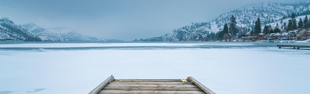 A dock overlooking a frozen lake with a light blue hue