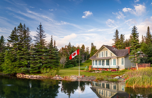 A spring pond in canada, with a house by the lake and can-air aeration in the pond.
