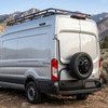 Surco TF300 black driver-side rear door tire carrier on silver Ford Transit van holding a full spare tire