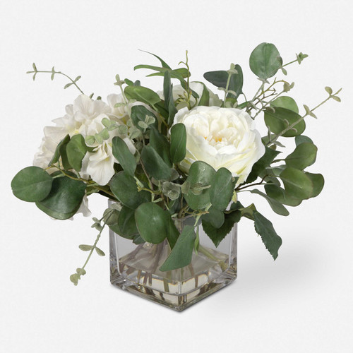 An airy mix as if freshly cut from the garden, featuring cream hydrangeas, roses, eucalyptus placed into a glass vase with faux water.