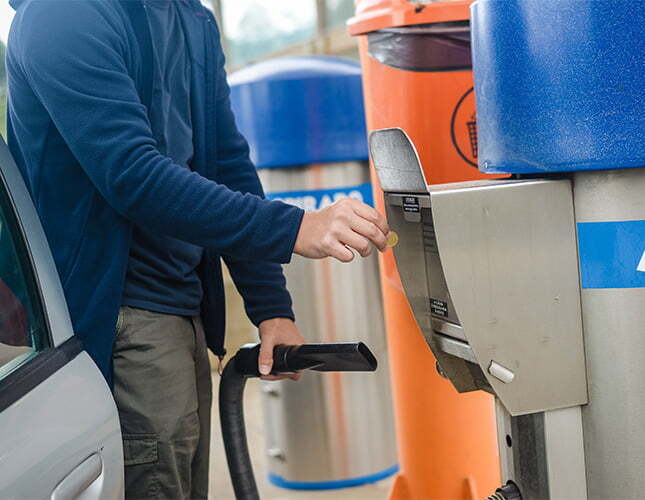 customer putting quarter into car wash vacuum