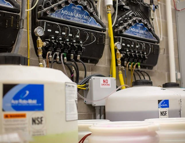 Jugs of chemicals feeding into a machine