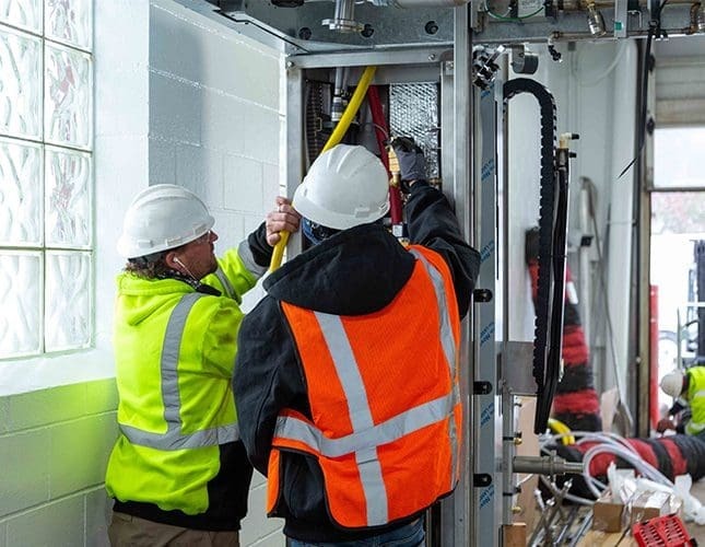 Two technicians doing work on equipment
