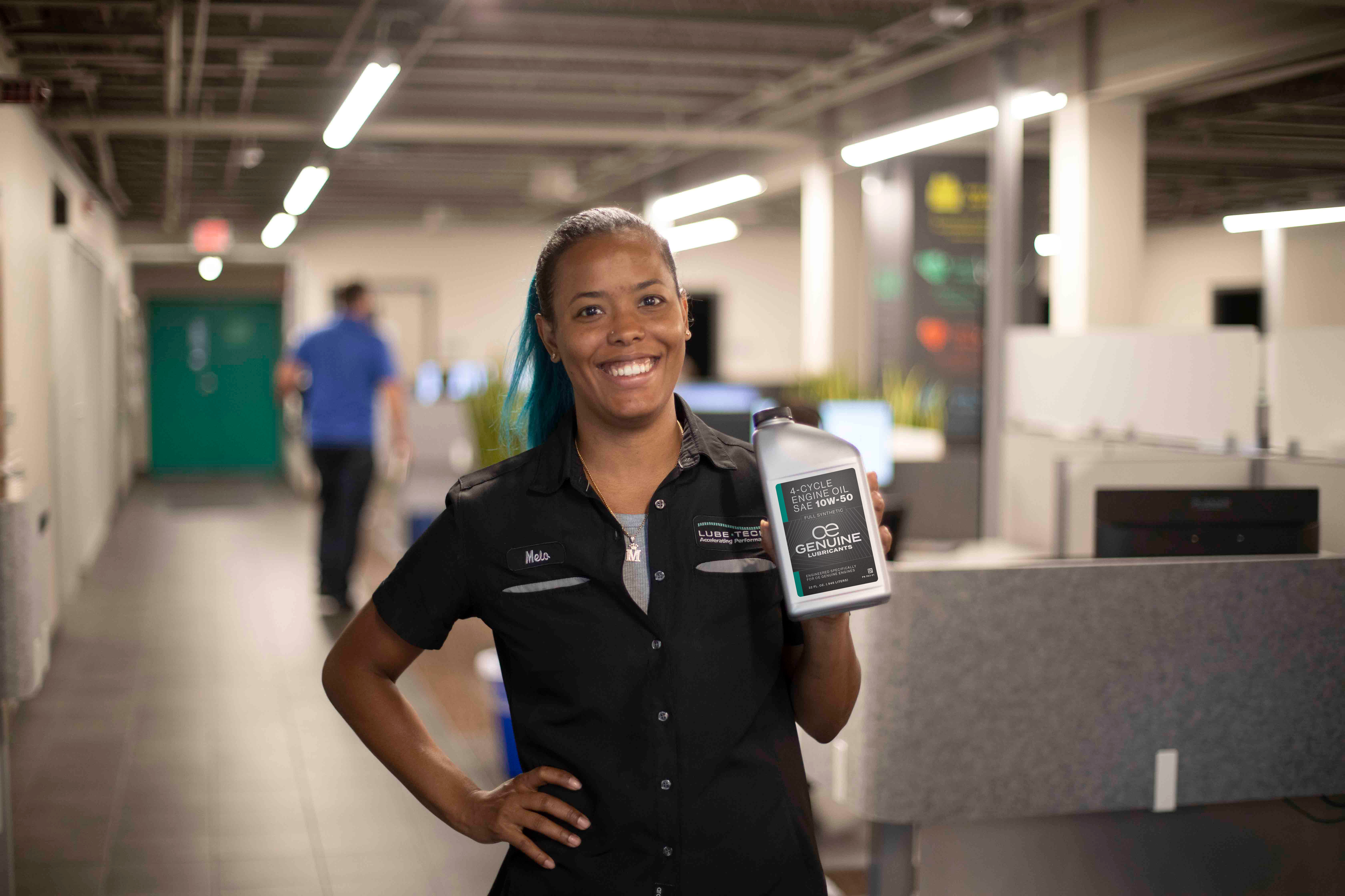 lubetech employees holding a bottle of motor oil in hand