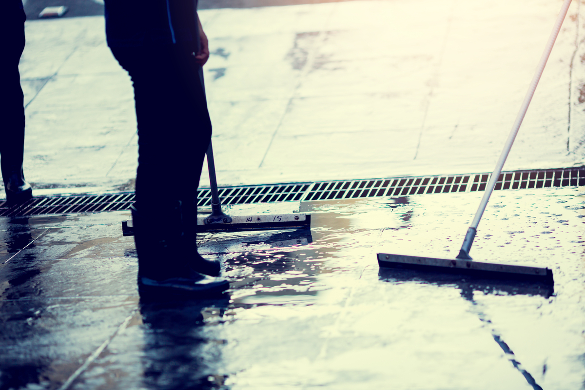 Worker scrubbing wet shop floor