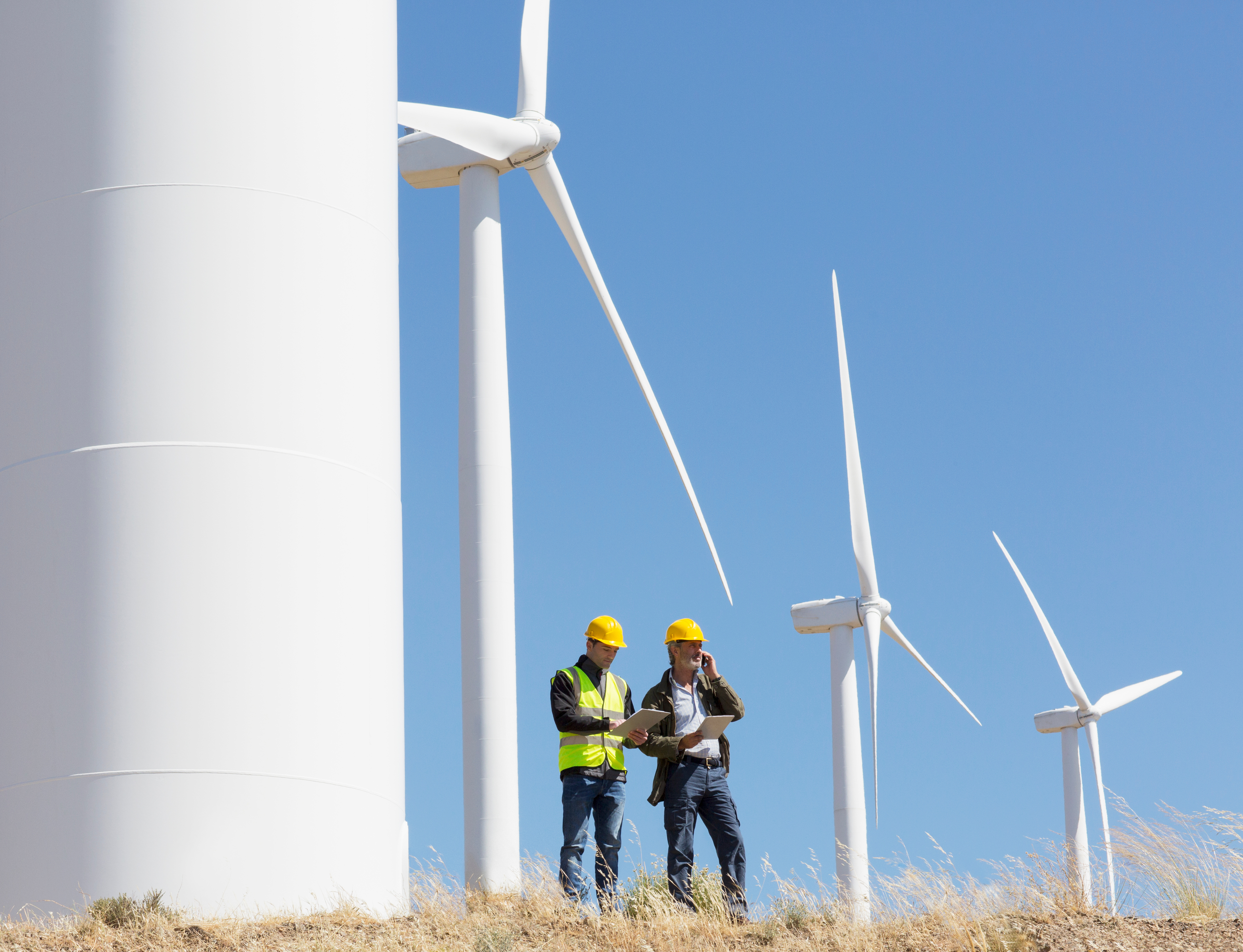 Two technicians standing on a wind farm