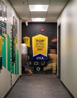 Hallway with a giant decal on the wall at the end that reads top work places 2021