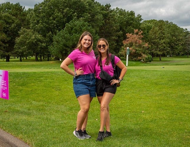 Two ladies in bright pink shirt posing for the camera