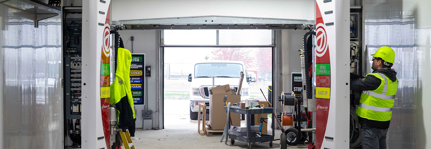 Technician servicing automatic car wash equipment