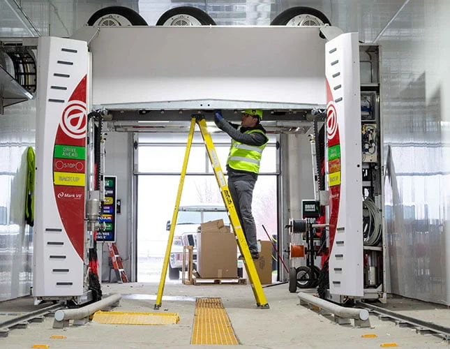Technician installing automatic car wash