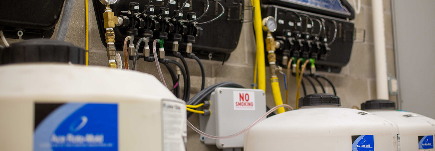 jugs of chemicals feeding in to machine