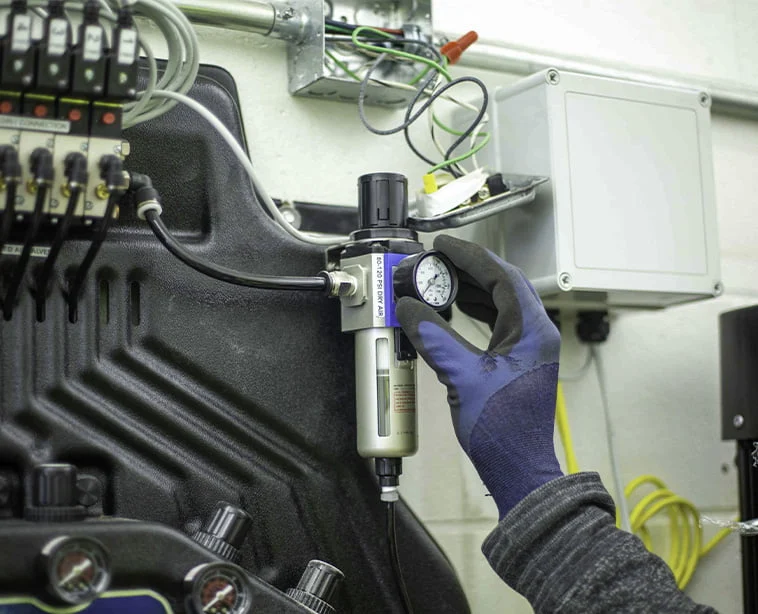 Technician use hand to touch an analog dial attached to a piece of equipment