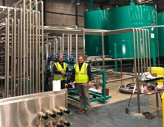 Two workers in a fluid factory