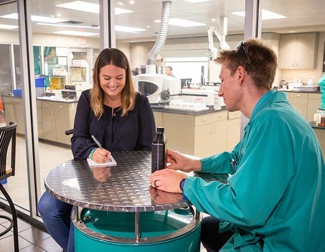 A woman and a man chatting by a table