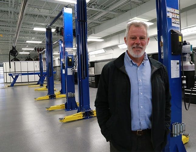 Man standing in front of car lifts