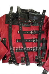 Rear view of a red and black leather straitjacket showing heavy-duty vertical adjustment straps, silver metal D-rings, and reinforced double stitching.
