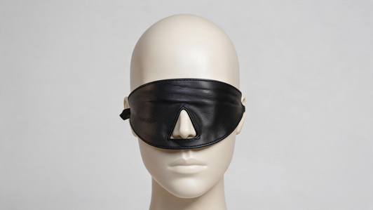 Shadow genuine leather blindfold with integrated nose pad, contoured eye mask design, adjustable buckle strap, and handcrafted black leather construction.