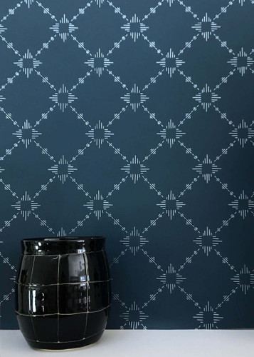 Silver metallic on a deep blue wallpaper in a diamond pattern with bursts.