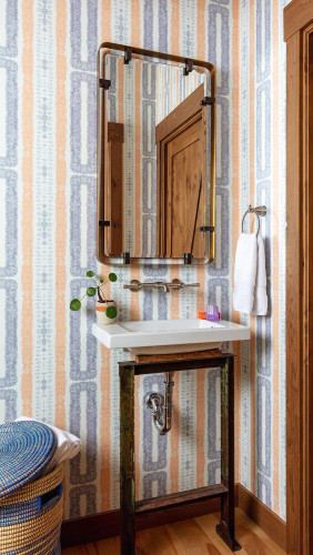 Coastal hand-dyed geometric wallpapered bathroom.