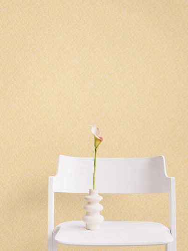 Delicate floral wallpaper in yellow behind and chair with a flower.