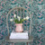 Wallpaper with off-white background, green foliage, off-white and light pink flowers with mustard details.