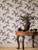 Botanical tree wallpaper covering the walls of an entry way in aubergine.