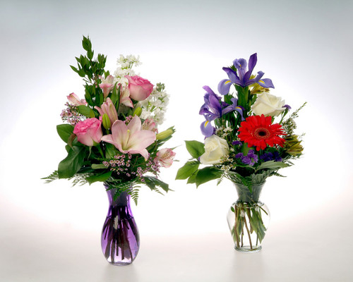 These modern vases are designed with seasonal flowers such as Blue Iris, Gerber Daiseys, colorful long lasting Roses and aromatic stock