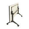 backside of tilting dry erase table is upright in whiteboard position and has black legs and wheels