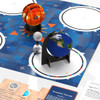 close up of ozobot ozogoes to the sun, earth, and moon kit with completed projects on mat