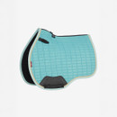A turquoise quilted saddle pad with a black underside, featuring black trim and a LeMieux logo, displayed from a side angle.