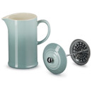 A blue cafetiere with  a press lid next to it