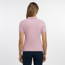 A woman with long hair, wearing a pink polo shirt, stands with her back to the camera against a plain white background.