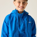 A smiling child wearing a bright blue rain jacket and fleece against a neutral background. The jacket's logo reads "Regatta Great Outdoors."