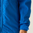 A close-up of a bright blue jacket with a visible zip and a folded sleeve, showing smooth fabric textures. The tone is casual and vibrant.