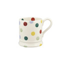 A side view of a white mug with multicoloured polka dots on a white background