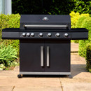 Black six-burner barbecue with closed hood, wide side shelves and double-door cupboard, shown on a garden patio.