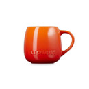 An orange mug with Le Creuset mug