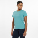 A woman stands confidently in a short-sleeve, teal athletic shirt paired with dark leggings, showcasing a sporty and stylish look.